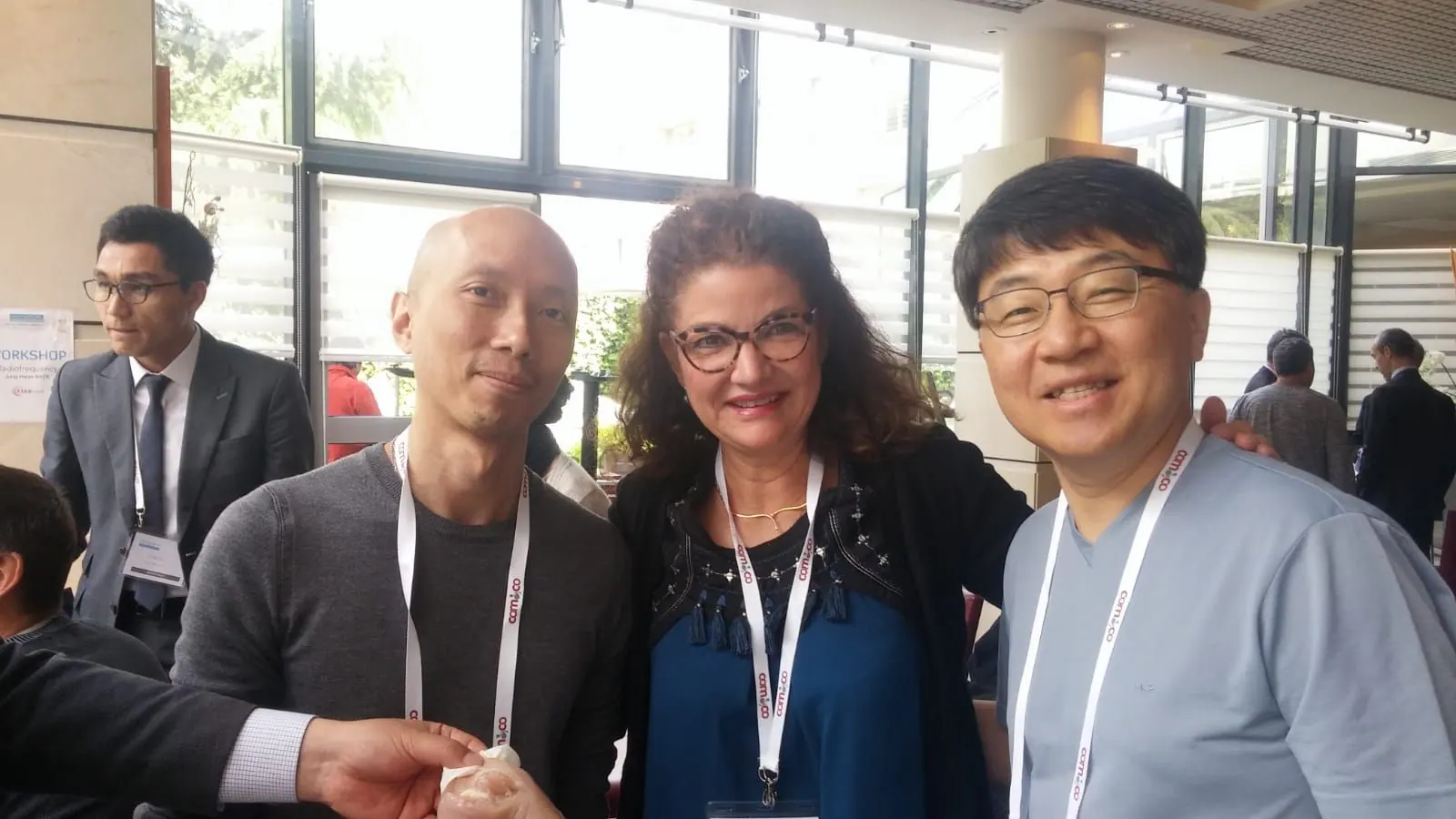 Le Dr Joëlle Huth entre deux confrères lors d’un congrès, badge au cou